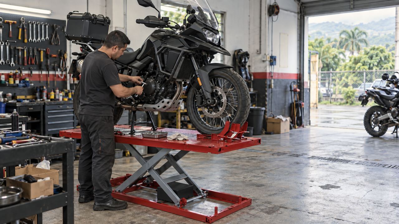 Técnico ajustando el motor de una moto de alto cilindraje montada sobre una mesa elevadora roja